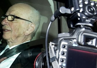 AFP - Photographers take pictures of News Corporation Chief Rupert Murdoch through his car window as he leaves his London home on July 14, 2011.