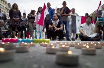 People demonstrate with Syrian national flags and candles in front of Lyon cityhall, centraleastern France, on July 16, 2011, in support for Syrian people.
