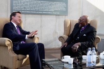 AFP - British Prime Minister David Cameron (L) speaks on July 18, 2011 with Bishop Desmond Tutu at Liliesleaf Farm, an apartheid-era hideout for Nelson Mandela and other freedom fighters in Johannesburg