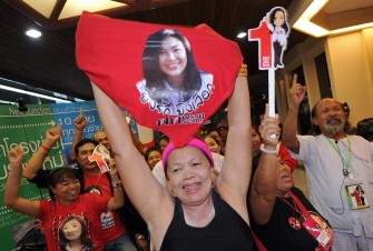AFP - Supporters of Yingluck Shinawatra shout slogans as they know Election Commission approved her at Puea Thai Party headquarter in Bangkok on July 19, 2011