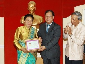 VUFO President Vu Xuan Hong (second from R) presents insignia to outgoing Lao Ambassador to Vietnam Sunthon Saynhachac at a ceremony in Hanoi on July 20