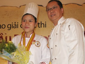 Vincent Tan (R), Executive chef of five-star Equatorial Saigon Hotel, poses for picture with Sy Kha Du after presenting a gold medal to her during the award ceremony in HCM City on July 22, 2011 (photo: Tuong Thuy)