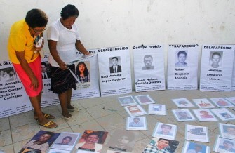 Members of the Caravan Step by Step to Peace spread pictures of their missing relatives on July 26, 2011 in Tapachula, Chiapas state, Mexico where the caravan arrived.