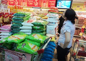 Shoppers buy state-subsidized products at a HCMC-based supermarket. Many participating firms of the price stabilization programs say they suffer heavy losses from this year increasing input cost (Photo: Minh Tri)