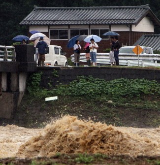 AFP - Local residents watch the flooded Igarashigawa River after heavy rain in Sanjo, Niigata Prefecture, on July 30, 2011