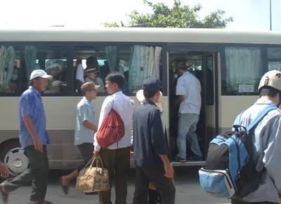 Xe chật cứng nhưng nhiều phụ xe tuyến Huế - Đà Nẵng vẫn chèo kéo thí sinh và phụ huynh đứng dọc đường. Ảnh: Văn Thắng.