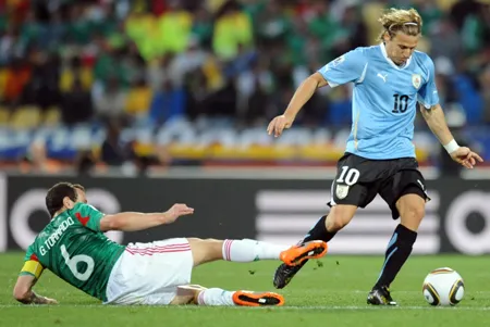 Diego Forlan (phải, Uruguay) đi bóng qua tiền vệ Gerardo Torrado (Mexico) tại World Cup 2010.