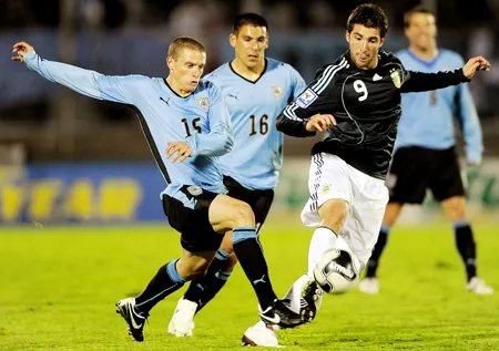 Tiền đạo Gonzalo Higuain (phải, Argentina) tranh bóng với tiền vệ Uruguay Diego Perez (trái).