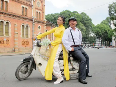 Một đôi uyên ương làm dáng chụm ảnh lưu niệm ngày cưới.
