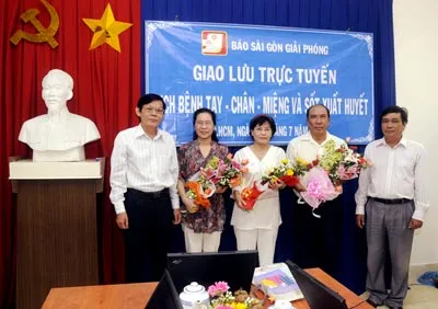 Phó TBT Báo Sài Gòn Giải Phóng Nguyễn Tấn Phong (bìa trái) tặng hoa các khách mời giao lưu. Ảnh: Mai Hải