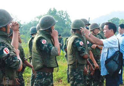 Các chiến sĩ thuộc Sư đoàn 302, Quân khu 7 vào vai lính biệt kích ngụy. Trong ảnh, đạo diễn chỉnh trang phục diễn viên trước cảnh quay.