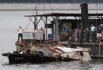 AFP - Rescuers lift up a sunken boat at the Moscow river, on July 31, 2011