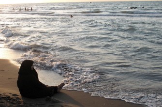 An Iranian woman sits along the shores of the Caspian Sea in Freydon Kenar, Mazandaran Province, on July 28, 2011