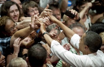 AFP - US President Barack Obama (R) shakes hands with the crowd at the Aragon Ballroom in Chicago, Illinios, August 3, 2011 after speaking for a fundraiser