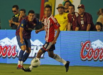 AFP - Barcelona's David Villa (L) fights for the ball during their match against Chivas Guadalajara