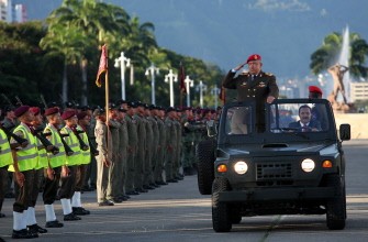 Venezuela's President Hugo Chavez stands in a vehicle as he attends the anniversary ceremony for the National Guard in Caracas August 4, 2011