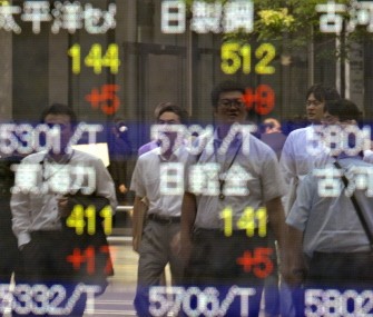 AFP - Pedestrians are reflected on a share prices board in Tokyo on August 10, 2011