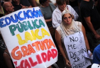 AFP - AFP - A protester dressed as a condom holds a placard reading "They won't let me go to Africa" during a demonstration against the public cost of the World Youth Day celebrations