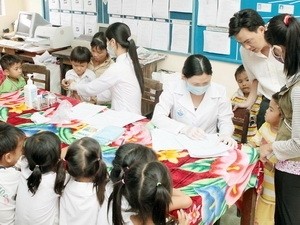 Medical workers examining kids to prevent the spread of hand-foot-mouth disease (Photo: Vietnamplus)