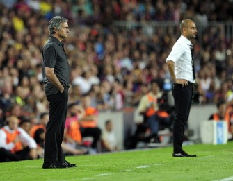 Real Madrid's Jose Mourinho (L) and Barcelona's coach Josep Guardiola (R) look on during the second leg of the Spanish Supercup football match