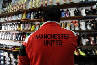 AFP - A customer wears a Manchester United football jersey at a shop in Denpasar, Bali, Indonesia on August 17, 2011