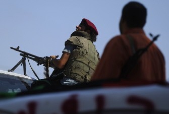 AFP - Lybian rebels take position during fighting against regime forces near the Gadayem forest, west of Tripoli, on August 21, 2011