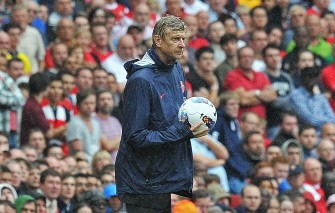 AFP - Arsenal manager Arsene Wenger holds the ball during the match between Arsenal and Liverpool