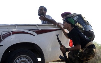 AFP - Libyan rebels duck for cover during fighting against regime forces near the Gadayem forest, west of Tripoli, on August 21, 2011