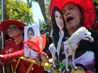 AFP- "Red Shirts" protesters shout slogans in support of Thai Prime Minister Yingluck Shinawatra while she delivered the inaugural policy statement to parliament in Bangkok on August 23, 2011