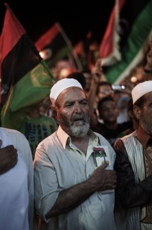 Libyans listen to the rebel national anthem as they celebrate on August 24, 2011