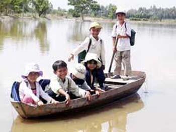 School children commuting by boat during the flood season in the Mekong Delta