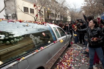 Fans toss flower petals at a hearse carrying the remains of Franco-Chilean film director, Raul Ruiz, uppon the arrival to Santiago on August 25, 2011.