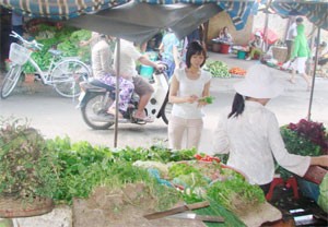 A woman shops at a market in HCMC. Continuous high inflation shows that Vietnam's economy is weak and it needs restructuring, officials say (Photo: Phan Hien)