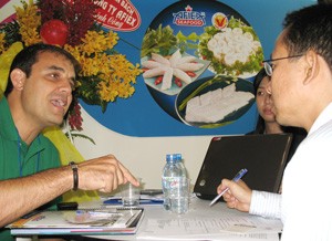 A foreign buyer (L) talks about business with representatives of Vietnamese seafood company Afiex An Giang during the 2011 Vietfish in Hochiminh City late June. Vietfish is Vietnam’s annual largest fisheries show, and aqua product is one of the country’s key export earners. (Photo: Tuong Thuy)