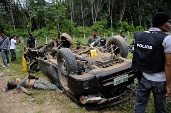 Thai police and explosive ordnance disposal (EOD) squad members inspect the wreckage of a car hit by a roadside blast which killed at least five security officers in Thailand's restive southern province of Narathiwat on August 26, 2011.