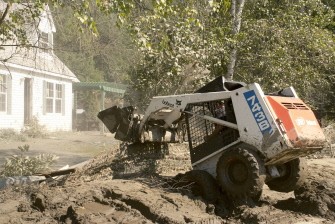 AFP - A compact tractor helps clean the side roads on August 30, 2011 in South Royalton, Vermont. Vermont is reeling from historic flooding in the wake of Tropical Storm Irene