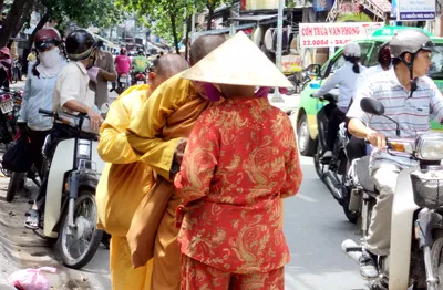 Người dân bố thí cho 2 sư giả.