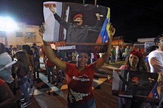 Supporters of Venezuelan President Hugo Chavez posters as they take part in a rally outside the military hospital in Caracas on August 31, 2011