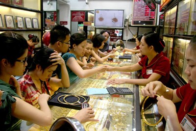 Customers buy jewelries at a gold shop.