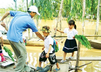 Children in An Giang Province are commuted to schools as floodwaters continue to rise in the Mekong Delta (Photo: SGGP)