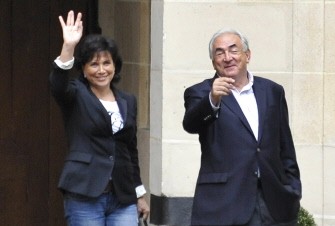 AFP - Dominique Strauss-Kahn (R) and his wife Anne Sinclair wave from the courtyard upon their arrival in their Paris home in Place des Vosges, on September 4, 2011