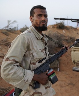 A NTC fighter from the Zintan Martyr Brigade rests near the front line close to Umm Khanfis, some 80 km east of Sirte, on September 4, 2011