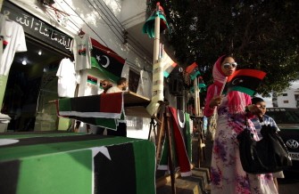 A Libyan woman buys the new flag adopted by the National Transitional Council (NTC) in Tripoli on September 6, 2011