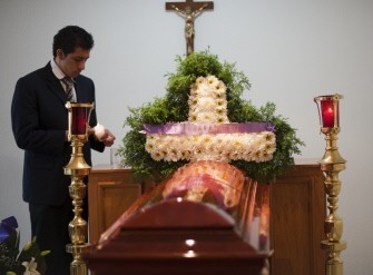 A funeral home staffer lights a candel beside the coffin of journalist Rocio Gonzalez Trapaga, a freelance reporter of Televisa channel during her funeral in Mexico City on September 2, 2011.