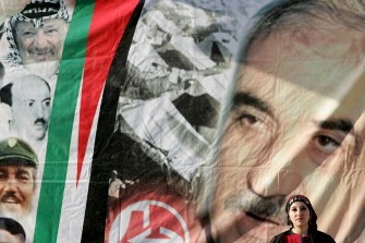 A Palestinian supporter of the Popular Front for the Liberation of Palestine (PFLP), gestures in front of a portrait of party leader late George Habash, during a march of support for the Palestinian bid for full United Nations membership.