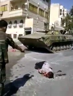 An image grab from footage uploaded on YouTube on September 7, 2011, shows what Syrian anti-regime activists say is a pro-government militia member dressed as a soldier allegedly firing his weapon at the corps of a man in the city of Homs on September 5, 2011.