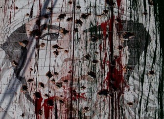 A bullet riddled portrait of ousted Libyan Leader Moammer Kadhafi painted on a wall of a building in the Libyan capital Tripoli is seen on September 10, 2011