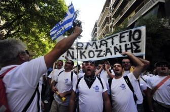 AFP - Greek taxi drivers hold a banner reading "Union of Kozani" as they chant slogans during a demonstration in central Athens on September 13, 2011.