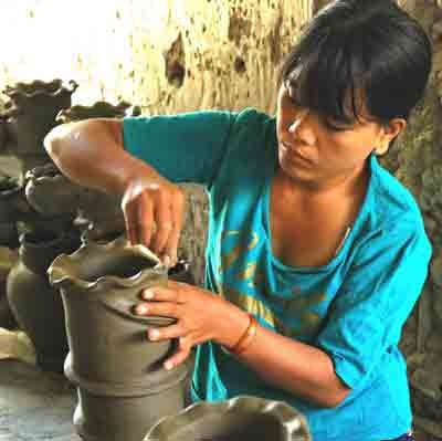 A craftswoman shaping wet clay at a pottery village (Photo: U. Phuong)