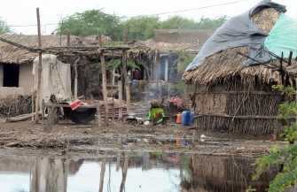 A Pakistani flood effected woman makes bread in a flooded area of Jhudo on September 16, 2011.